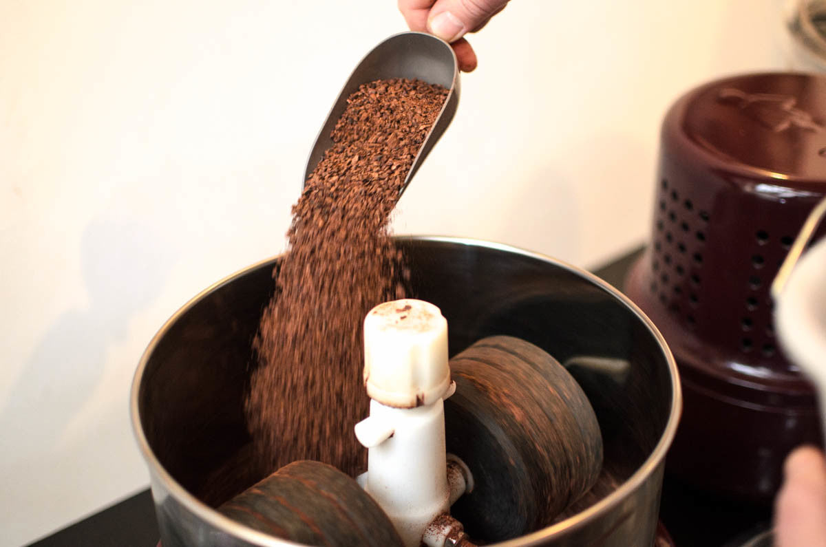 Die Kakaobohnenstücke kommen in den Melangeuer, wo sie viele Stunden gemahlen werden.